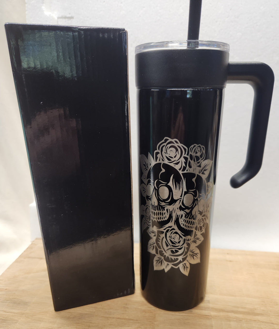 Bold. Intricate. Timeless. This 20oz black tumbler features a laser-engraved design of stylized skulls framed by blooming roses—an LDJ tribute to strength, memory, and the beauty found in contrast. Packaged in a matching black gift box, it’s built for those who carry legacy in every sip.
• 	20oz insulated tumbler with handle, lid, and straw
• 	Laser-engraved skull and rose design
• 	Includes matte black gift box for premium presentation
• 	Hand wash recommended to preserve engraving
• 	Designed and packaged